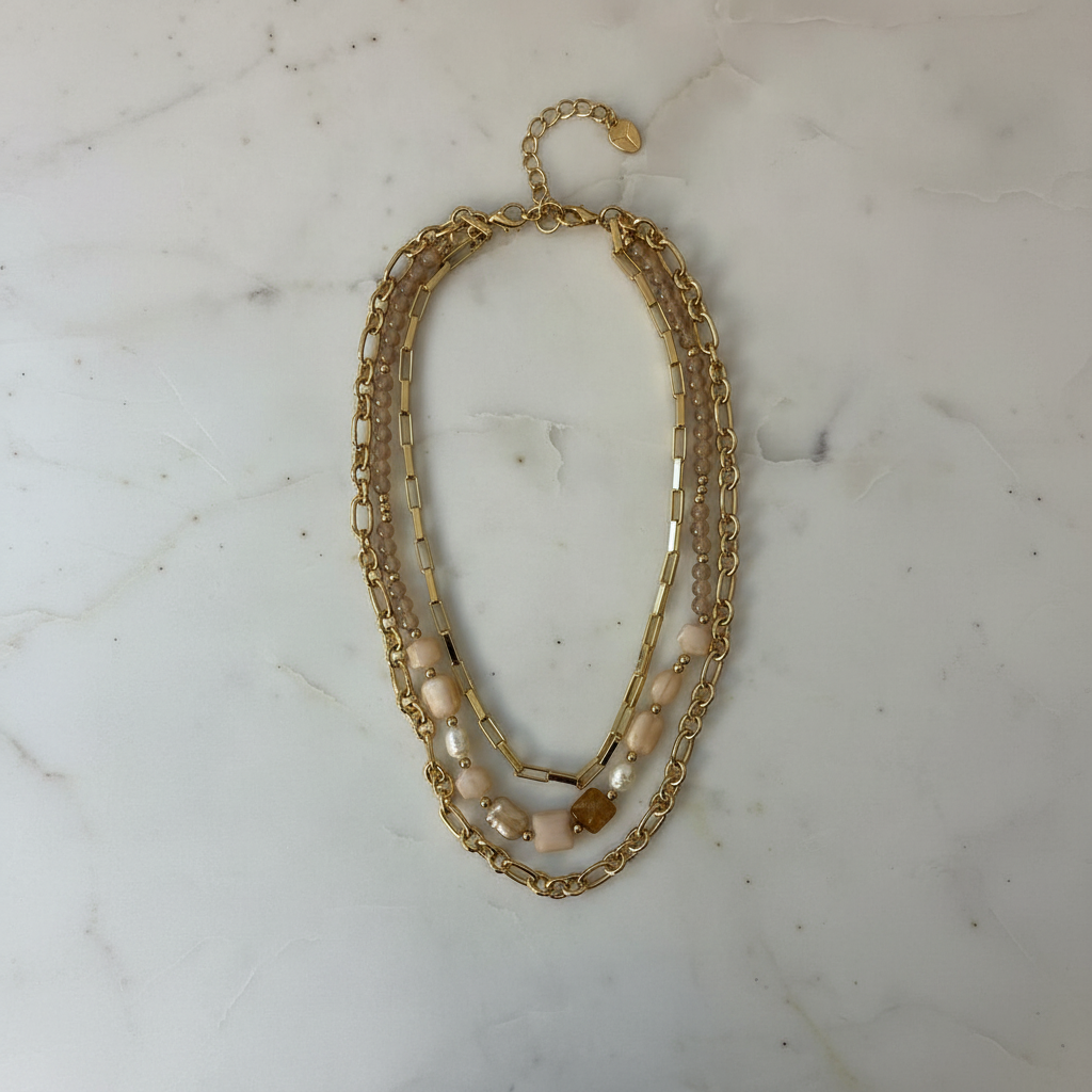 Colar dourado com pérolas em mármore