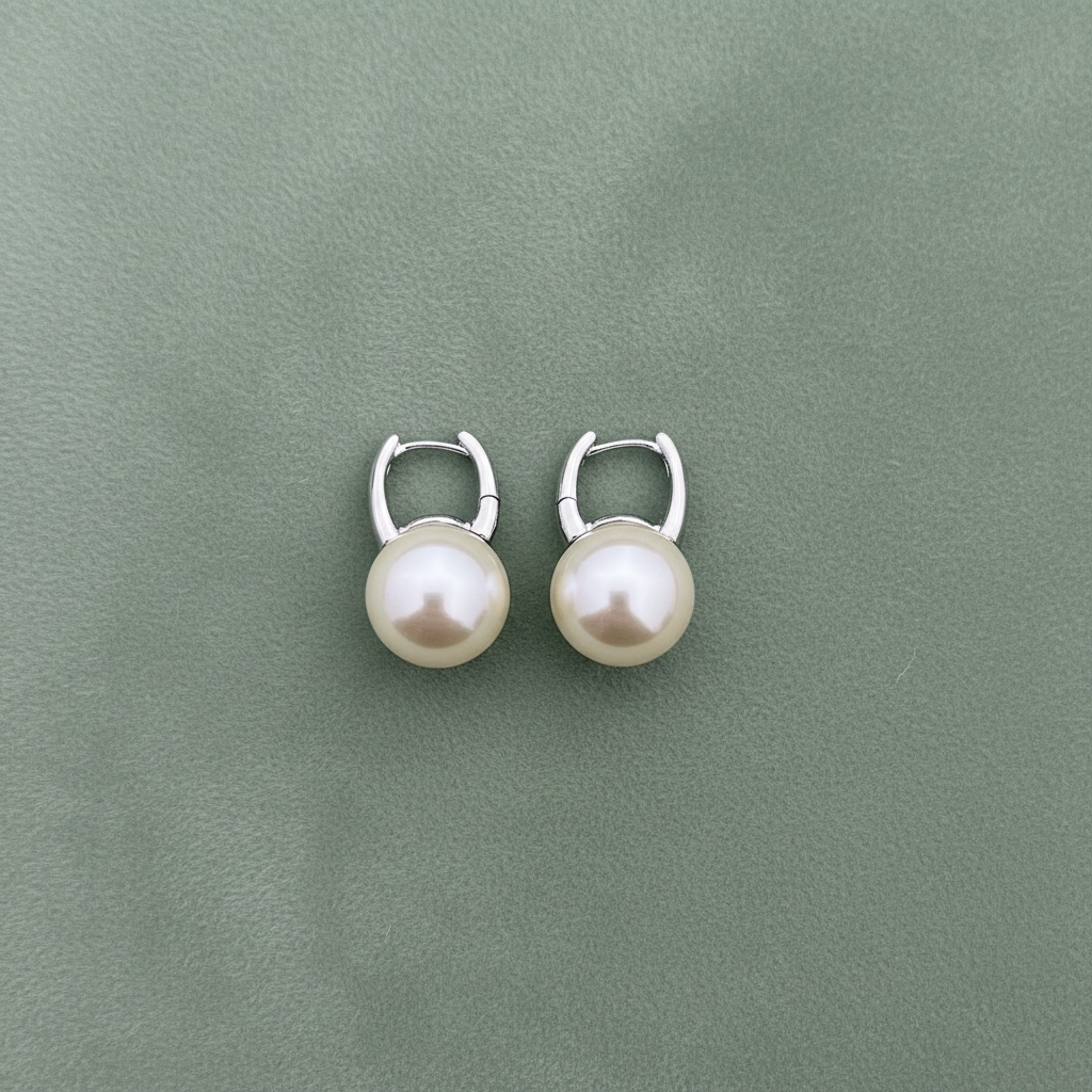 Flat lay silver pearl huggie earrings