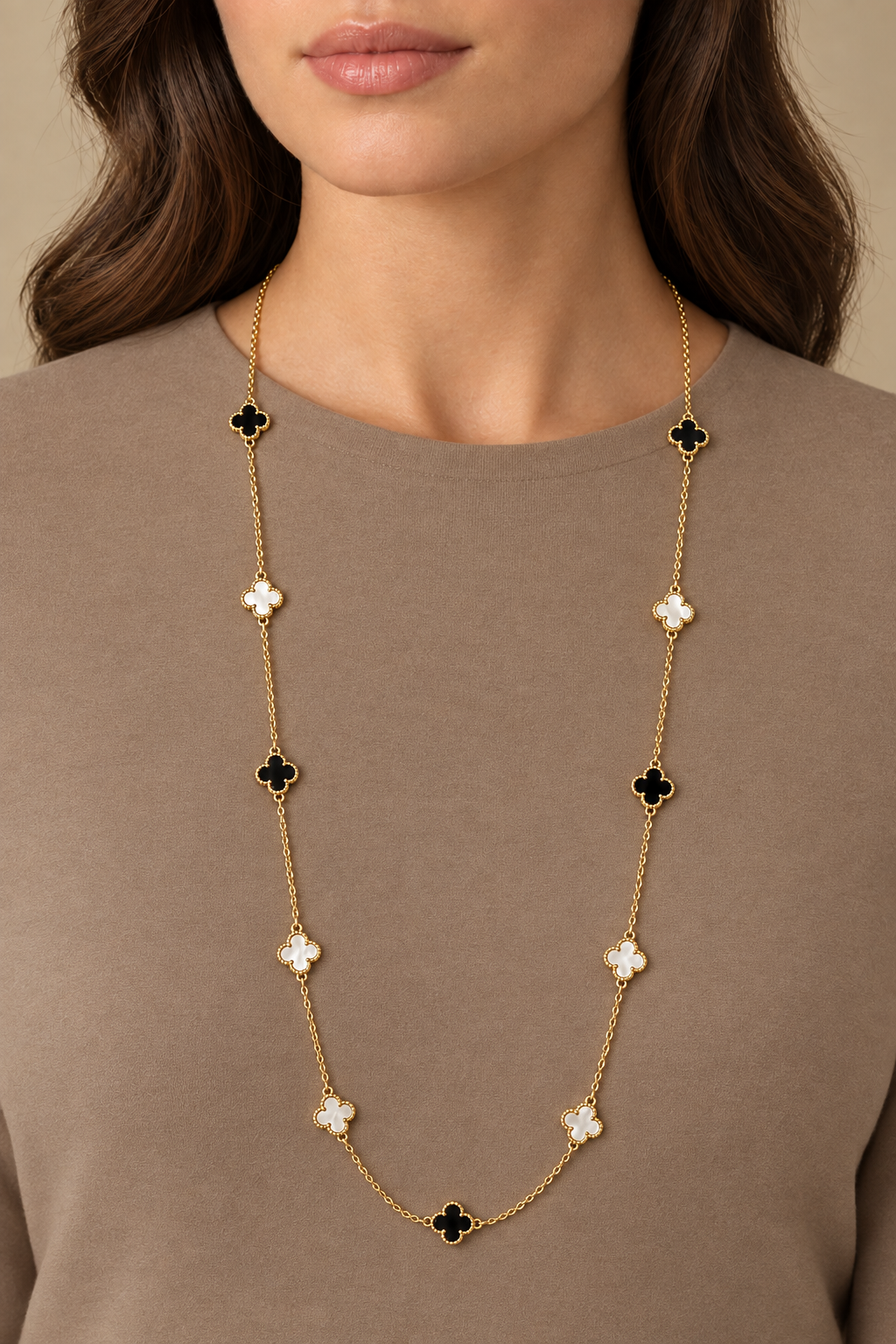 Model wearing necklace against a plain taupe top